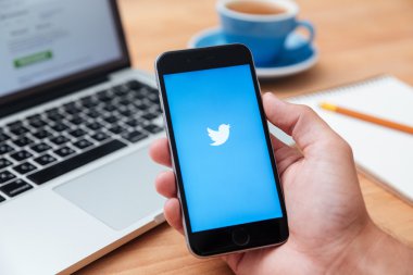 Iphone 6'yı tutan adam Twitter uygulamasını gösteriyor