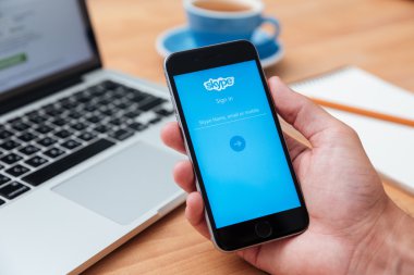 İPhone 6 gösteren Skype uygulaması tutan adam