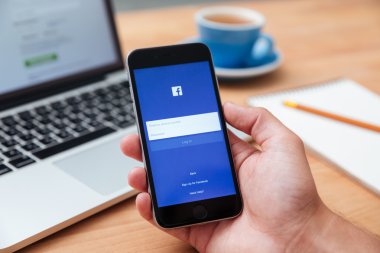 İPhone 6 gösteren Facebook app tutan adam