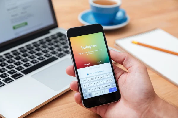 Man holding iphone 6 showing Instagram app — Stock Photo, Image