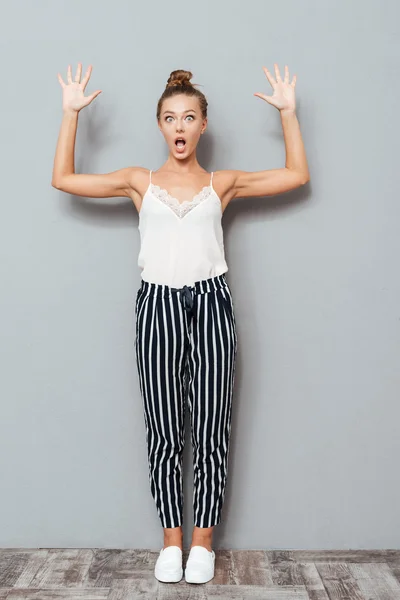 Full length portrait of a shocked woman showing her palms