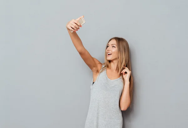 Sonriente chica joven haciendo foto selfie aislado — Foto de Stock