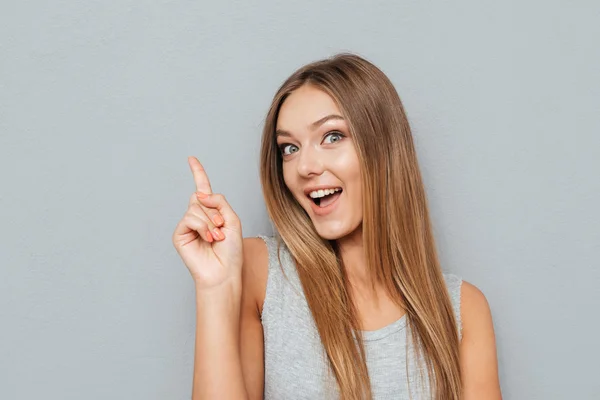 Молодая счастливая женщина тычет пальцем в пространство копирования — стоковое фото
