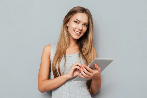 Портрет смеющейся женщины с помощью планшетного компьютера изолирован — стоковое фото