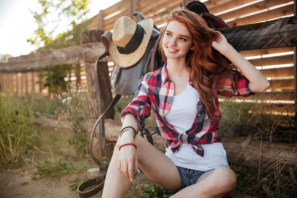 Glücklich lächelndes junges Cowgirl, das sich am Ranchzaun ausruht — Stockfoto