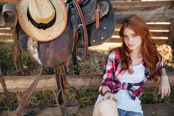 Piękna Ruda młoda kobieta cowgirl siedzi na zewnątrz — Zdjęcie stockowe