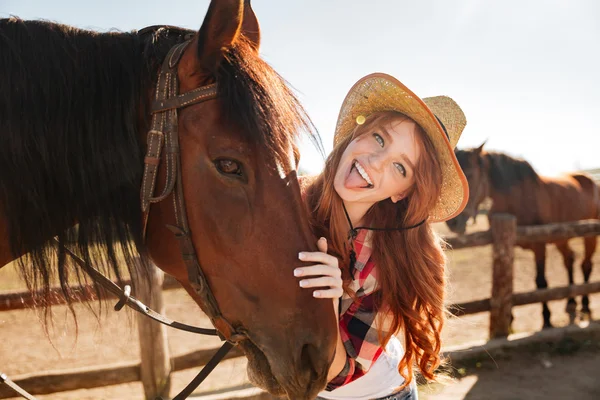 Vidám nő cowgirl ló állandó és bemutatás nyelv — Stock Fotó