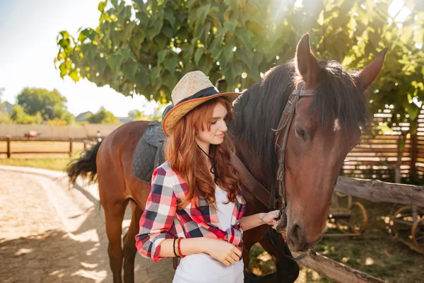 女人女牛仔站和照顾马匹的村庄 — 图库照片