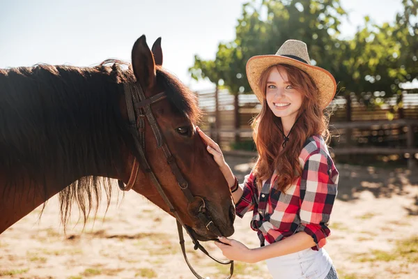 Vrij mooie cowgirl, het verzorgen van haar paard op ranch — Stockfoto