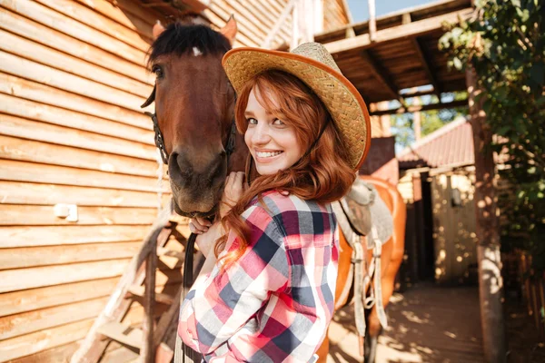 Весела мила молода жінка пастушка в капелюсі з конем — стокове фото