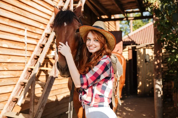 Lycklig kvinna cowgirl står och kramar hennes häst — Stockfoto