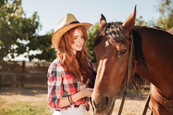 Vrouw cowgirl het verzorgen van haar paard op ranch — Stockfoto