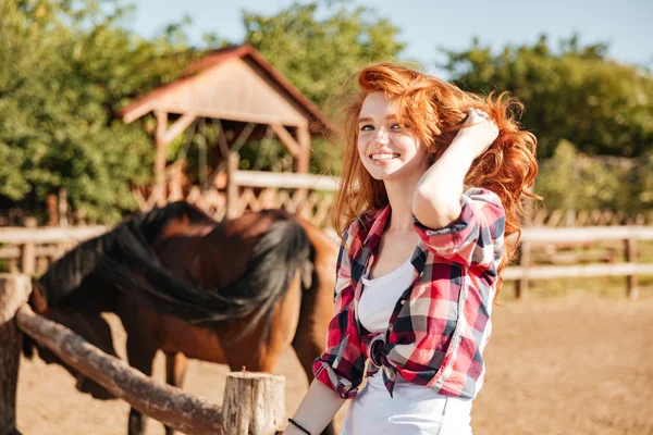 Mulher sorridente cowgirl com cavalo sentado no rancho — Fotografia de Stock