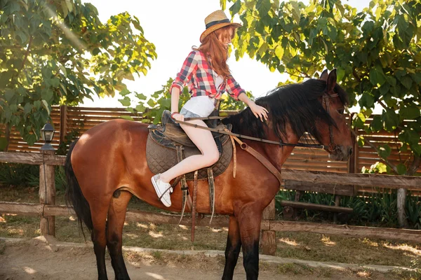 Szczęśliwa kobieta cowgirl uśmiechając się i jazda konna koń — Zdjęcie stockowe