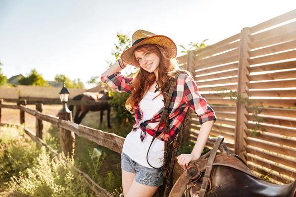 Gelukkig mooie jonge vrouw cowgirl in hoed op ranch — Stockfoto