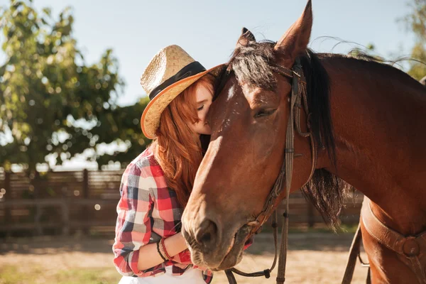 Bella donna cowgirl in piedi e baciare il suo cavallo — Foto Stock