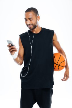 Sepet topu tutan kulaklık ile akıllı telefon kullanarak Fitness adam