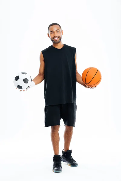 Hombre deportivo africano feliz sosteniendo baloncesto y pelota de fútbol —  Fotos de Stock