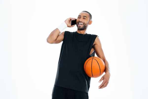 Riéndose alegre jugador de baloncesto africano hablando por teléfono móvil — Foto de Stock