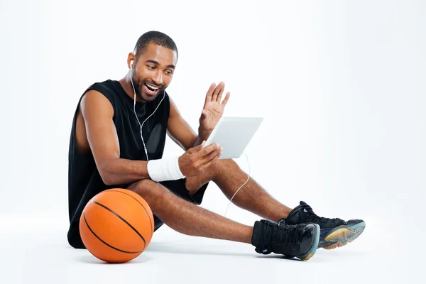 Man basketball player sitting and listening to music from tablet — Stock Photo, Image