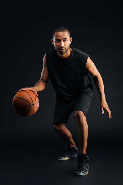 Retrato de un serio deportista africano jugando al baloncesto — Foto de Stock