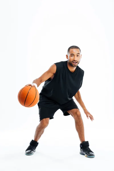 Jovem jogador de basquete feliz sentado no parque com uma toalha