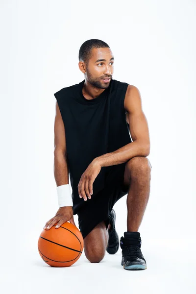 Attractive young man basketball player standing on one knee — Stock Photo, Image