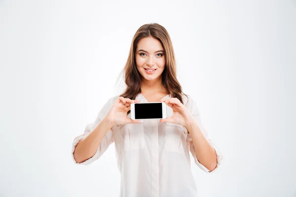 Leende kvinna som visar tom smartphone skärm isolerad på vit bakgrund — Stockfoto