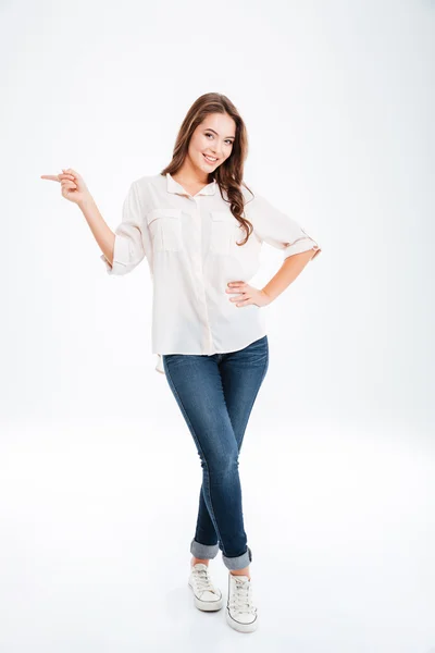 Full length portrait of a happy woman pointing finger away — Stock Photo, Image