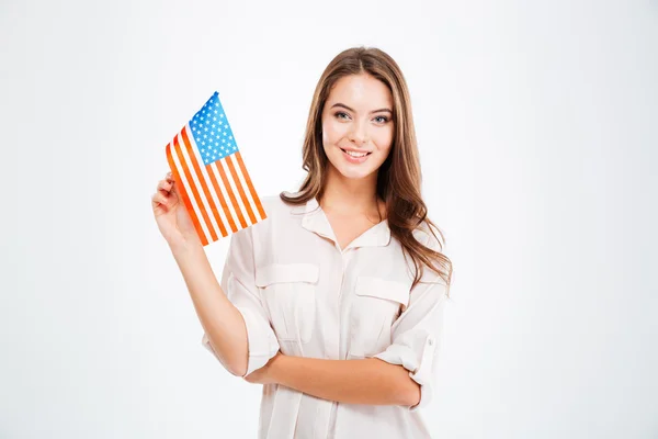 Woman holding USA flag and looking at camera — Stock fotografie