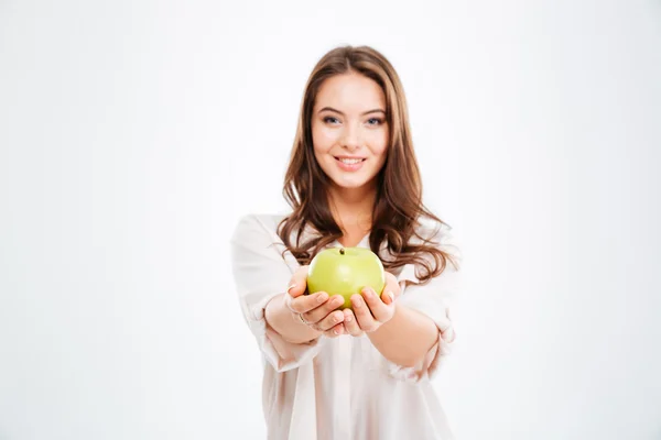 Sorrindo jovem mulher dando maçã na câmera — Fotografia de Stock