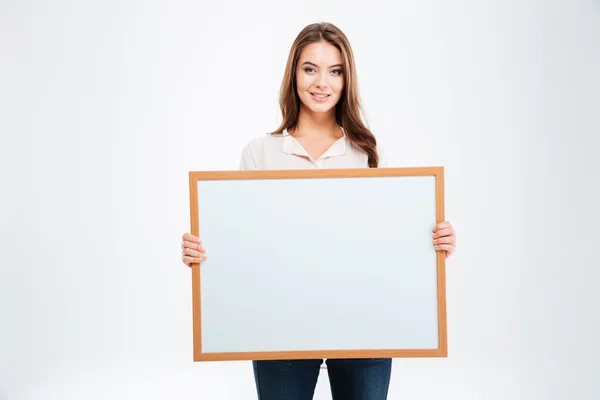 Portret van een lachende jonge vrouw die blanco bord toont — Stockfoto