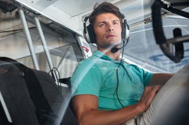 Ciddi genç adam pilot, kabinde özel uçak