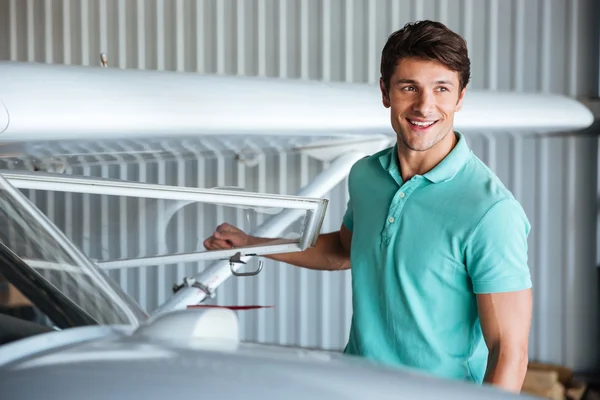 Joyeux jeune homme pilote près du petit avion — Photo