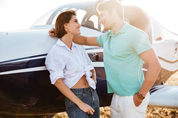 Casal conversando e flertando perto de avião privado — Fotografia de Stock