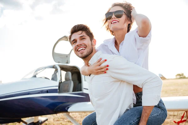 Couple laughing and having fun on runway near private plane — Stock Photo, Image