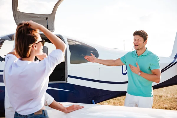 Pilot inviting passengers on board of private airplane — Stock Photo, Image
