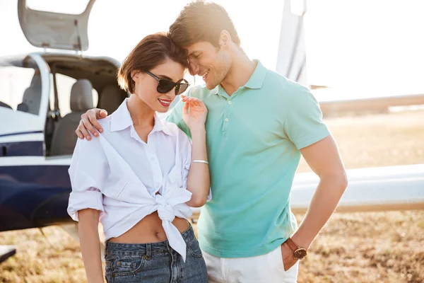 Couple standing and hugging near small airplane — Stock Photo, Image