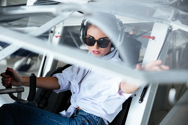Donna pilota in auricolare seduto in piccolo aereo — Foto Stock