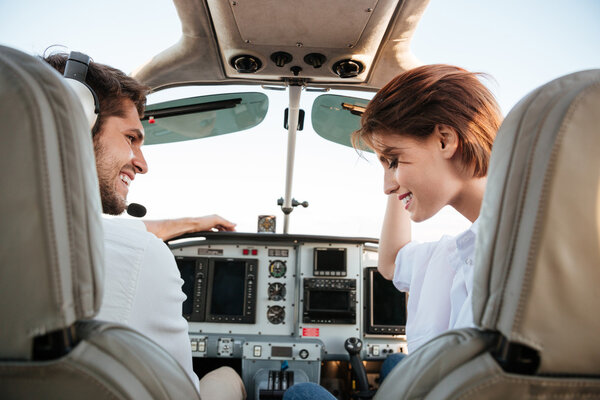 Couple looking at each other while sitting inside airplane cabin