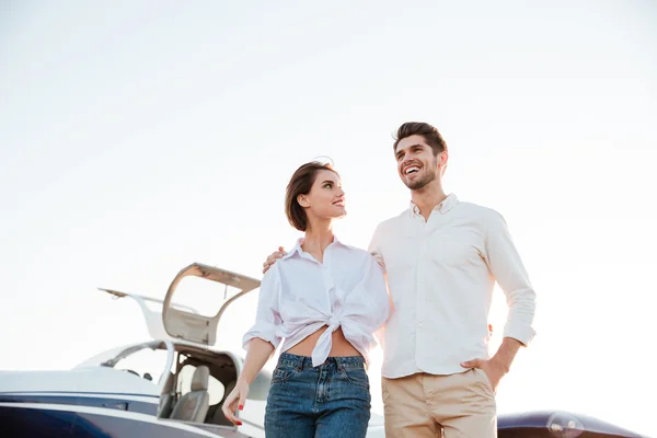 Giovane bella coppia insieme con aereo su sfondo — Foto Stock