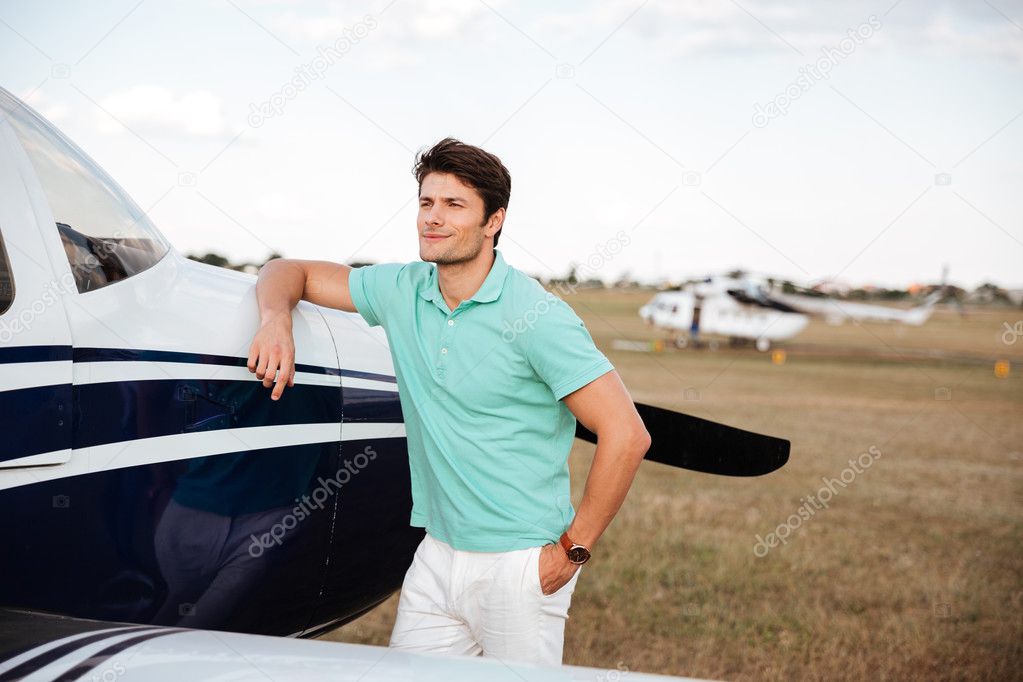 Smiling man standing near small airlane