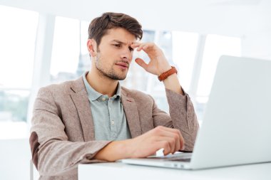 Dalgın genç işadamı laptop ile çalışma