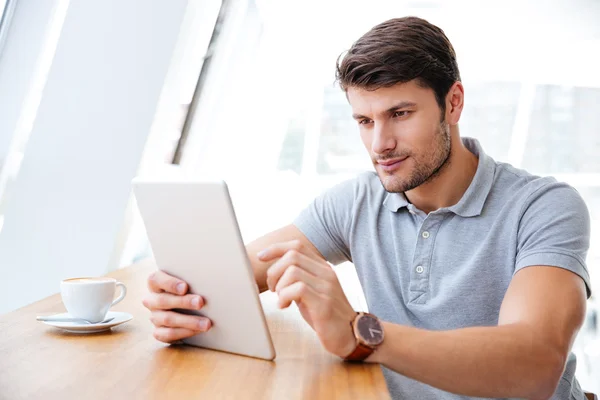 Jonge zakenman in casual kleding met behulp van Tablet PC binnenshuis — Stockfoto