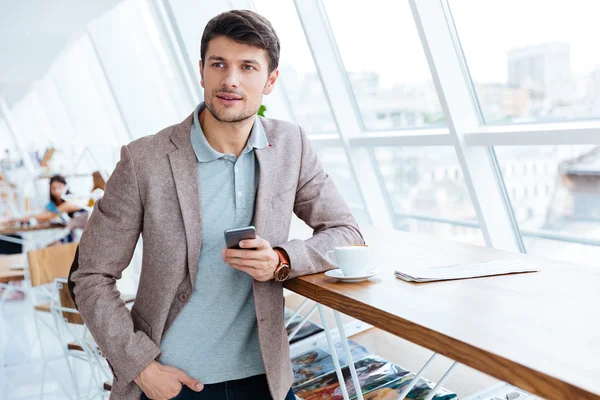 Mann in Jacke hält Handy in der Mittagspause — Stockfoto