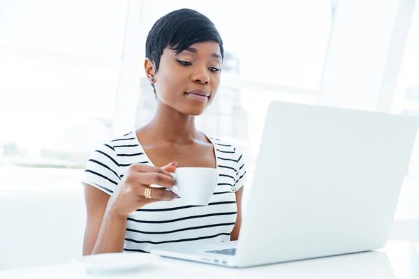 Pensive african american young businesswoman sitting at workplace — Stock Photo, Image