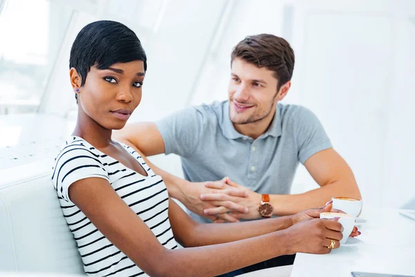 Gelukkig knap man zitten en drinken koffie met zijn vriendin — Stockfoto