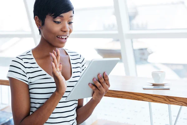 Счастливая афро-американская бизнесвумен держит планшетный компьютер и машет — стоковое фото