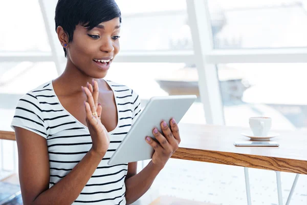 Happy afro american businesswoman holding tablet computer and waving — ストック写真