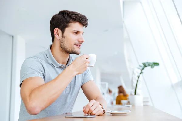 Sorrindo casual jovem bebendo café no café Imagem De Stock